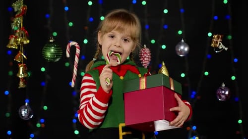 Cute Child Elf Enjoys Christmas Candy Cane