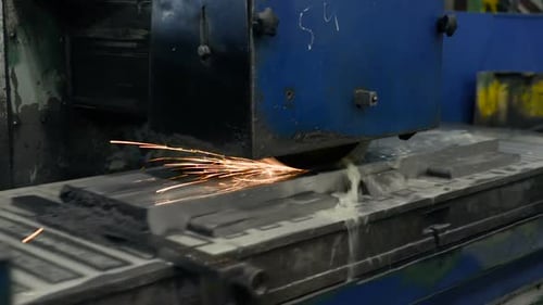 Trabajo de una rectificadora de superficies industrial. Rectificado de una pieza metálica plana