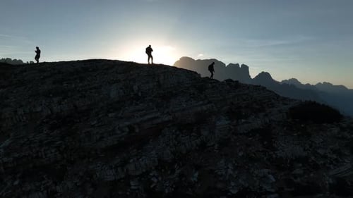 Female and male hikers at the top of the mountain at sunrise.