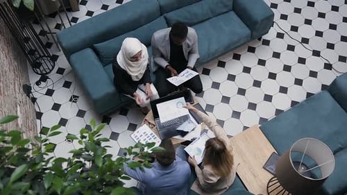Diverse Colleagues Discussing Charts and Graphs in Office