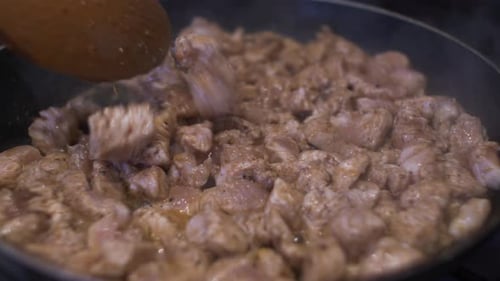 Sizzling Chicken Pieces Being Stirred In Pan. Close Up, Locked Off