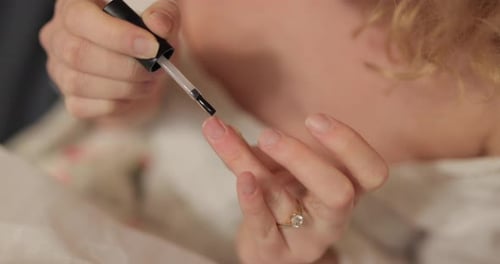 Woman Applying Nail Polish at Home