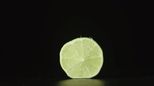 Menschliche Hand nimmt eine halbe Limette weg