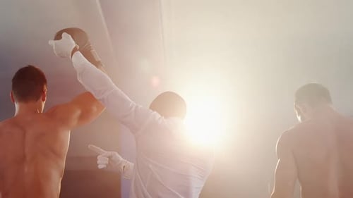 Un boxeur tient la main du vainqueur après avoir annoncé