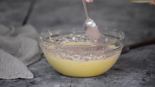 Woman Combining Batter with Chocolate Powder in Bowl