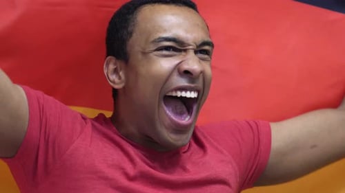 Enthusiastic Young Adult Cheers with German Flag