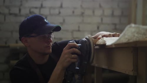 Carpentry Workshop Man Worker Grinding the Side of a Wooden Plank