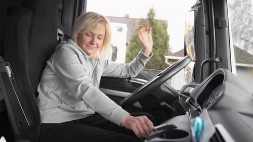 Woman Truck Driver Sitting Inside of a Truck