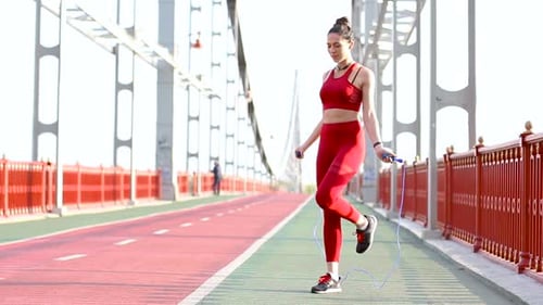 Woman Jump Roping on Bridge Path Exercising