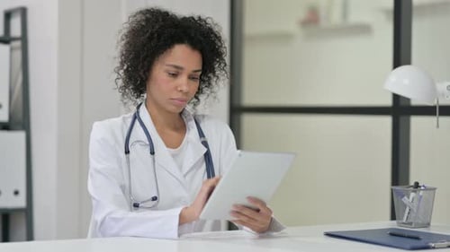 Woman Doctor Using Tablet at Office Desk