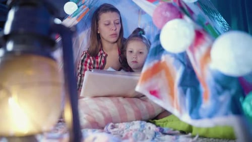 Woman and Child Reading in a Tent