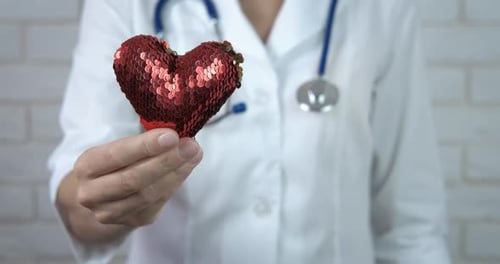 Doctor Holding a Red Sequin Heart