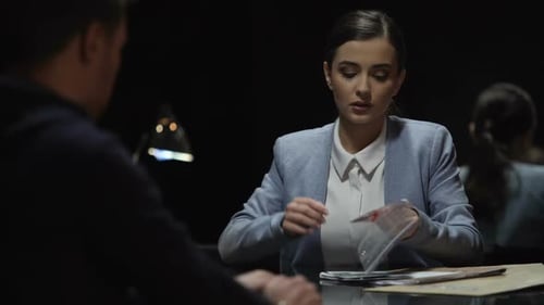 Woman Questioning Suspect with Evidence at Night