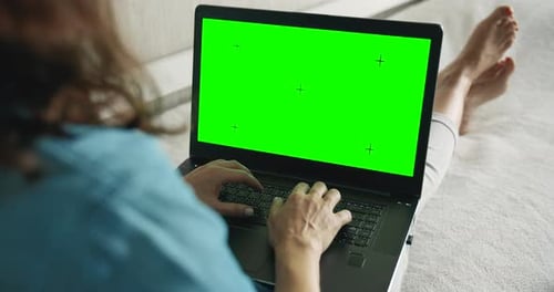 Woman Typing on Laptop with Green Screen