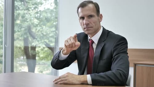 Man in Suit Points Towards the Camera
