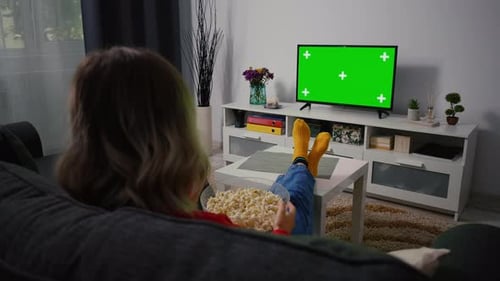 Young Woman Watching Television with Green Screen Chroma Key,