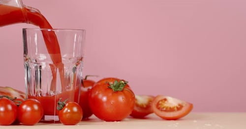 Tomato Juice Is Poured From a Jug Into a Glass.
