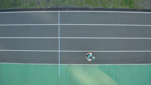 Woman Jogging at an Outdoor Track