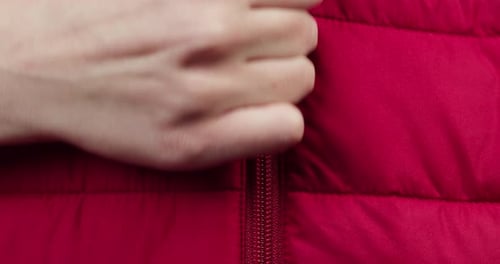 Hand Zipping Up Red Clothes Closeup