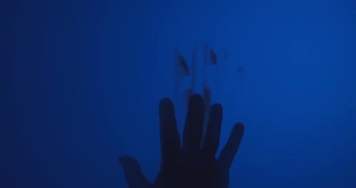 Silhouette of a Hand on Dark Blue Background