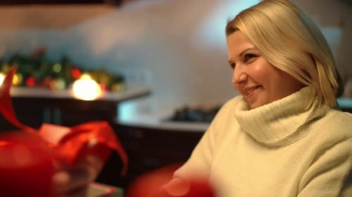 Woman Receiving a Christmas Gift with a Smile