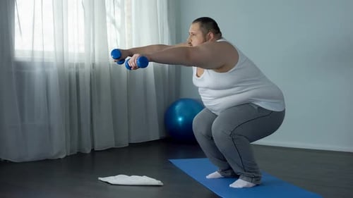 Adult doing Squats with Dumbbells on Yoga Mat