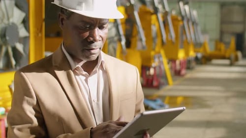 African American Engineer Using Tablet in Factory