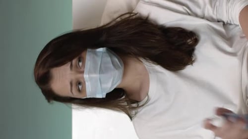 Tir vertical Femme dans un masque pulvérisé antiseptique antibactérien autour d'elle-même Quarantaine Panique