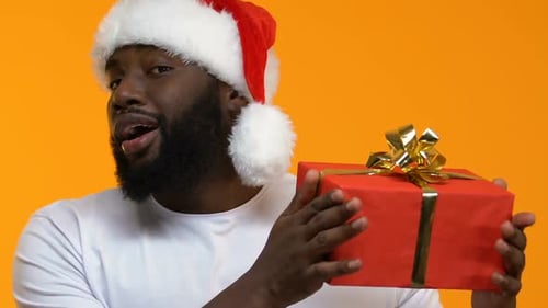 Man with Santa Hat Holding Christmas Gift