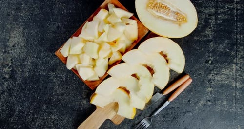 In Scheiben geschnittene reife Melone auf dem Schneidebrett und Teller.