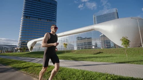 Pro Runner Runs on a City Road Athlete Trains in an Urban Environment on a Sunny Day Modern Urban