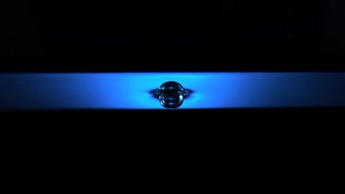 Water Droplet Ripples on Blue Illuminated Surface