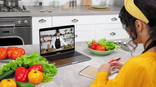 Woman Taking Online Cooking Lesson in Kitchen
