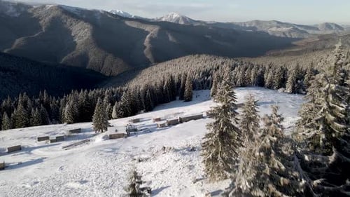 Drohne fliegt über dem Winterwald und enthüllt Bergkette
