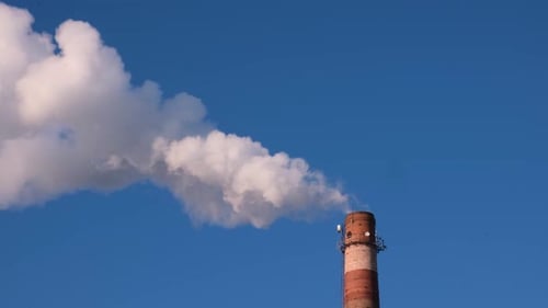 Smokestack Emitting White Smoke Against Blue Sky