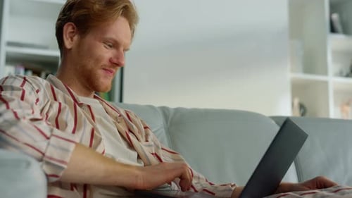 Young Man Video Calling on Laptop in Living Room
