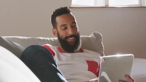 Man Relaxing at Home with Tablet on Couch