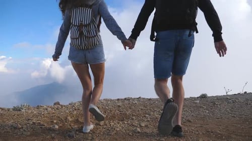Young Couple of Tourists with Backpacks Running to the Edge of Beautiful Canyon and Victoriously