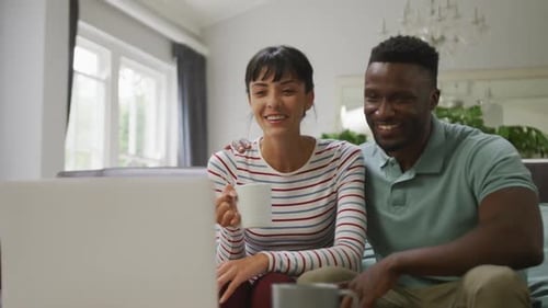 Smiling Couple Relaxing at Home with Laptop