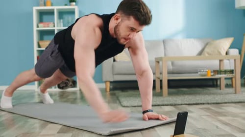 Muscular Man Doing Plank Exercise at Home