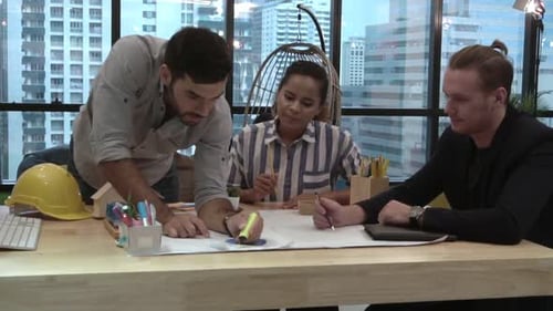 Gruppe kreativer Geschäftsleute, die sich am Schreibtisch am Arbeitsplatz unterhalten