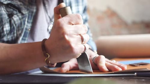 Leather Worker Cuts Tan Leather With Sharp Tool