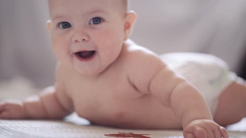Smiling Baby Lying on Stomach Close Up