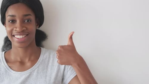 Smiling Woman Giving Thumbs Up on White Background