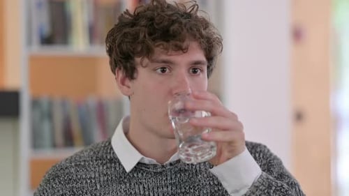 Porträt eines jungen Mannes, der Wasser trinkt