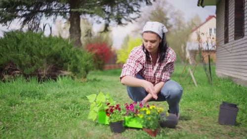 Woman in Spring Plants Flowers in the Garden