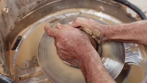 Hands Shaping Clay on a Pottery Wheel