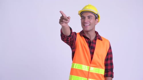 Young Happy Hispanic Man Construction Worker Directing and Pointing Finger