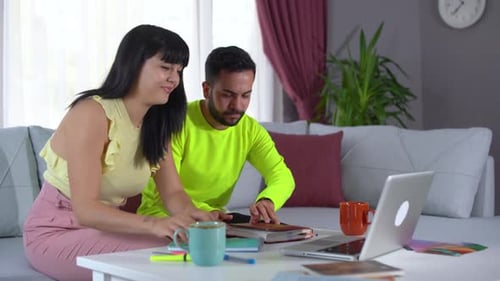 Young Couple Working at Laptop in Bright Living Room
