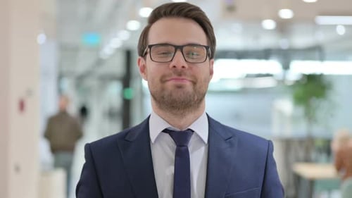Man in Suit and Glasses Looks at Camera
